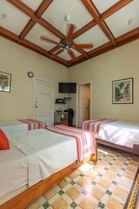 two beds in a room with a ceiling at La casa azul in Cartagena de Indias