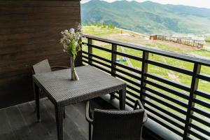 a table with a vase of flowers on a balcony at Shahdag Hotel & Spa in Shahdag +140 photos