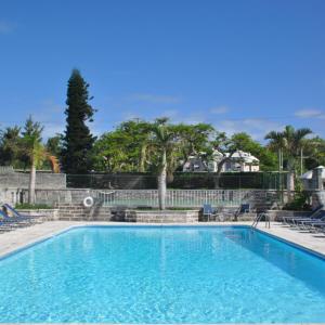 una gran piscina azul con sillas y árboles en Willowbank Resort, en Somerset