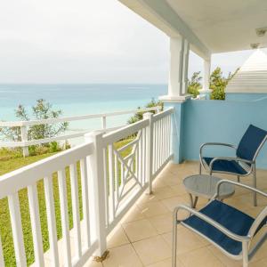 a porch with two chairs and the ocean at Willowbank Resort in Somerset