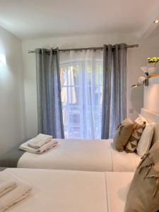 um quarto com 2 camas e uma janela em The Old Village Studio Vilamoura em Vilamoura