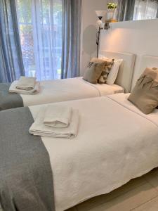 two beds in a room with towels on them at The Old Village Studio Vilamoura in Vilamoura