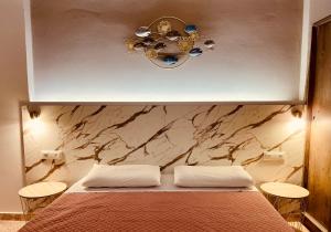 a bedroom with a bed and a marble wall at Peter's Place in Faliraki