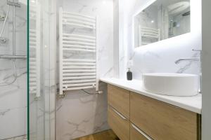 a white bathroom with a sink and a shower at Le nid des Ducs in Dijon