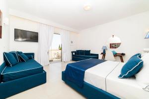 Dormitorio blanco y azul con cama y sofá en Residenza Al Pesce D'Oro, en Amalfi