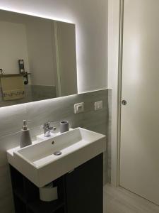 La salle de bains est pourvue d'un lavabo blanc et d'un miroir. dans l'établissement Da Nord a Sud - Loft con soppalco, à Termoli