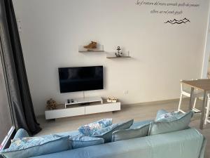 un soggiorno con divano blu e TV a schermo piatto di Da Nord a Sud - Loft con soppalco a Termoli