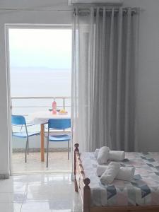 um quarto com uma cama, uma mesa e uma janela em NaDim rooms em Himare
