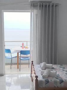 a bedroom with a bed and a table and a window at NaDim rooms in Himare +18 photos
