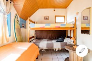 a bedroom with two bunk beds and a table at Casa Hostel Mosaicos DyA in Florianópolis