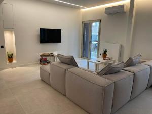 a living room with a couch and a flat screen tv at Sapfo Luxury Apartment in Athens in Athens