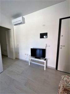 a living room with a flat screen tv on a white wall at Affittimoderni La Maddalena - MADA12 in La Maddalena