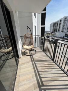 zwei Stühle auf dem Balkon eines Gebäudes in der Unterkunft Waters edge in Abu Dhabi