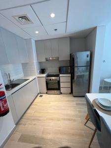 uma cozinha com armários brancos e electrodomésticos de aço inoxidável em Waters edge em Abu Dhabi