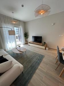 een woonkamer met een bank en een tv bij Waters edge in Abu Dhabi