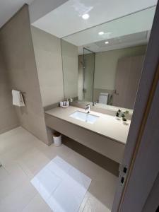 ein Badezimmer mit einem Waschbecken und einem großen Spiegel in der Unterkunft Waters edge in Abu Dhabi