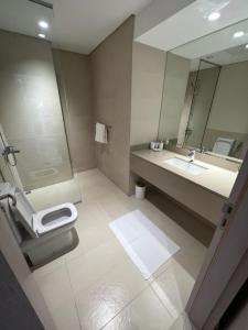 ein Badezimmer mit einem Waschbecken, einem WC und einem Spiegel in der Unterkunft Waters edge in Abu Dhabi
