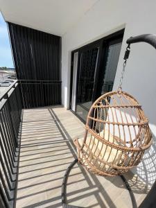 eine Veranda mit einem Rattankorb auf dem Balkon in der Unterkunft Waters edge in Abu Dhabi