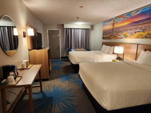 una camera d'albergo con due letti e una televisione di Days Inn by Wyndham Tucumcari a Tucumcari