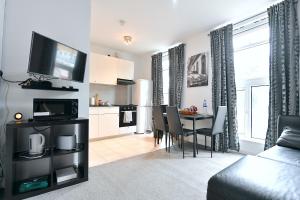 a living room with a kitchen and a dining room at City Central Apartments in London