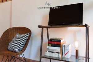 uma televisão numa mesa com livros e uma cadeira em Appartamenti Ridolfi em Empoli