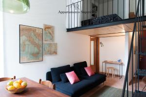 sala de estar con sofá azul y mesa en Appartamenti Ridolfi en Empoli