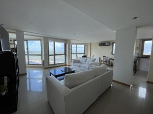 - un salon avec des canapés blancs et une table dans l'établissement Soñar mirando el mar Playa Varese Hola Sur, à Mar del Plata