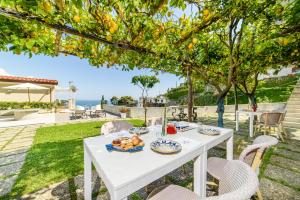 Residenza Al Pesce D'Oro في أمالفي: طاولة بيضاء عليها طعام تحت شجرة