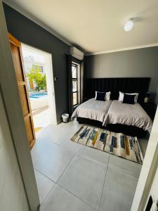 a bedroom with a bed and a door leading to a yard at Kates Nest Guesthouse Oshakati in Oshakati