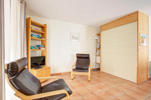 a living room with a sliding door and a chair at Obelisque 1A - Studio au rez-de-chaussée in Port-Vendres