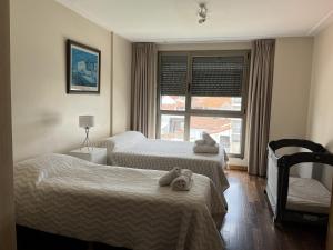Cette chambre comprend 2 lits et une fenêtre. dans l'établissement Soñar mirando el mar Playa Varese Hola Sur, à Mar del Plata