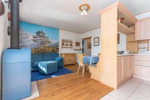 a kitchen and living room with a view of the mountains at Condominio Orsa Maggiore 12 in Falcade