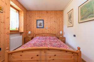 a bedroom with a wooden bed in a room at Condominio Orsa Maggiore 12 in Falcade