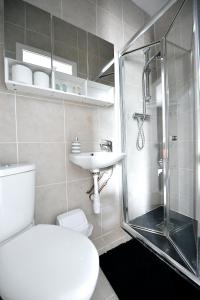 a bathroom with a shower and a toilet and a sink at City Central Apartments in London