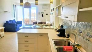 a kitchen with a sink and a living room at Residence Bellevue in Leuca