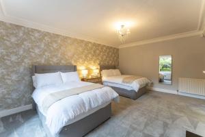 1 dormitorio con 2 camas y lámpara de araña en The Lindsay House en Stirling