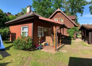 a small house with a porch on a yard at Letnisko Laba in Pobierowo