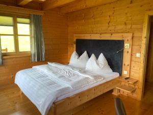 ein Schlafzimmer mit einem Bett in einem Blockhaus in der Unterkunft Bio Bauernhof Perneißl Apartment in Bischofshofen