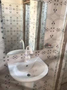 a bathroom with a white sink and a mirror at MHALO BEACH LODGE 