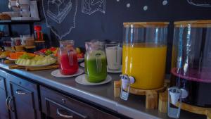 a counter with two glasses of juice and plates of fruit at Pousada Constellation Lodge in Campos do Jordão