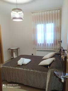 a bedroom with a bed with pillows and a window at Vivienda El Olivo in Valderrobres