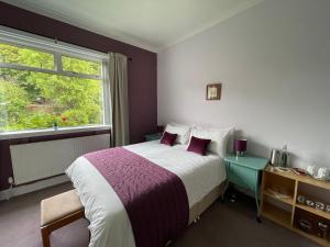 una camera d'albergo con letto e finestra di Blackburn Villa B&B ad Ayr