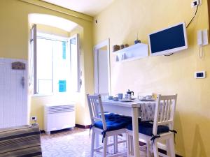 ein Esszimmer mit einem Tisch und Stühlen sowie einem TV in der Unterkunft La Casa di Lenù in Riomaggiore