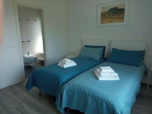 een slaapkamer met 2 bedden met blauwe lakens en een spiegel bij Casa Vittoria Guest House in Romano D'Ezzelino