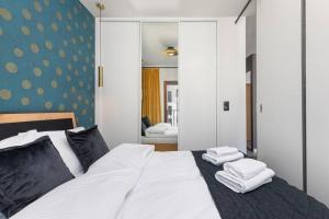 Un dormitorio con una cama blanca con toallas. en ECRU Port Praski Stylish Apartment near Old Town WWA33, en Varsovia