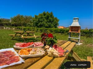 een picknicktafel met verschillende soorten eten erop bij La Maruca Beach Santander in Santander