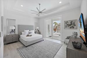 Un dormitorio blanco con una cama blanca y un televisor. en Waterfront home with pool, spa and kayaks/paddleboards, en Marco Island 30 fotos más