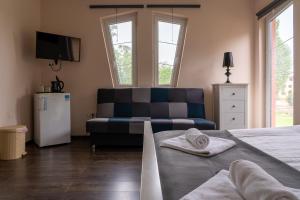 a living room with a couch and a bed at Accomo Apartmanház in Siófok
