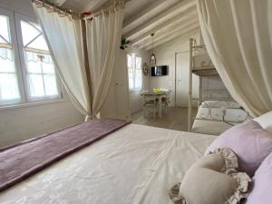 ein Schlafzimmer mit einem großen weißen Bett und einem Tisch in der Unterkunft Villa Poggio Ulivo Pool-Apartments in Rivoli Veronese
