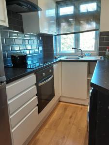 a kitchen with a sink and a stove at Feel at Home in Elmers End
